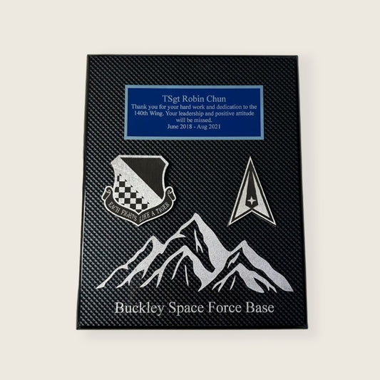 carbon fiber finish plaque with engraved mountains, wood coins, and an engraved plate in blue and silver color scheme