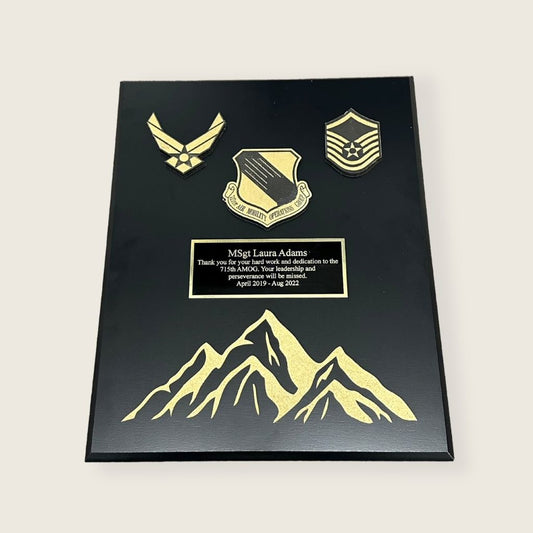 black finish plaque with engraved mountains and wood coins in black and gold color scheme