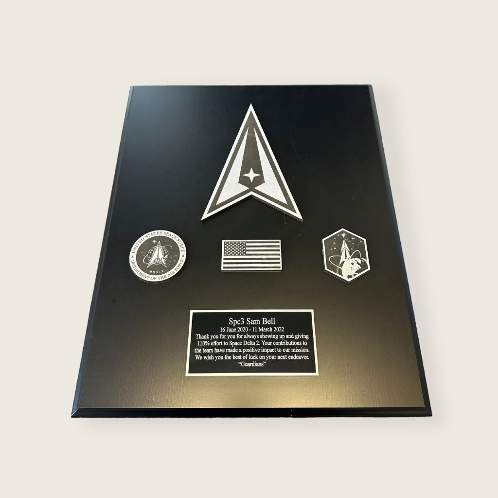 space plaque in black finish with large wood space logo, 3 wood coins, and an engraved plate in black and silver finish